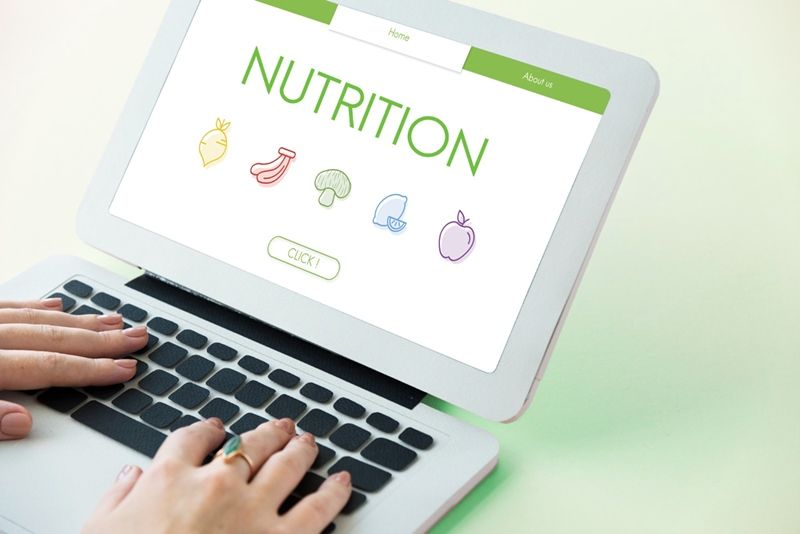 woman holding her laptop with nutrition written on the screen