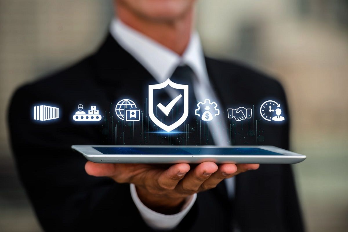 A man holding a tab which has business and security icons 