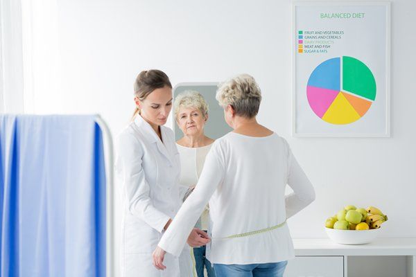 Health professionals taking measurements of a woman