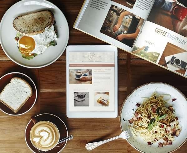 Magazine and tablet kept on the table with blogs and article in focus 