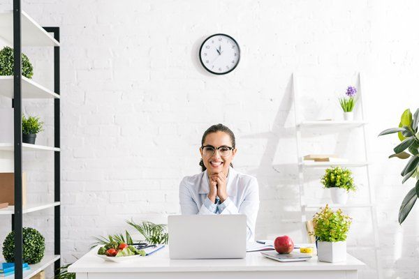 A nutritionist working on a laptop in her office