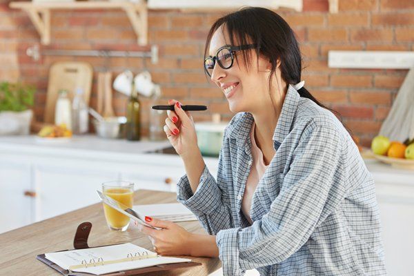 A woman noting things down in her tablet 